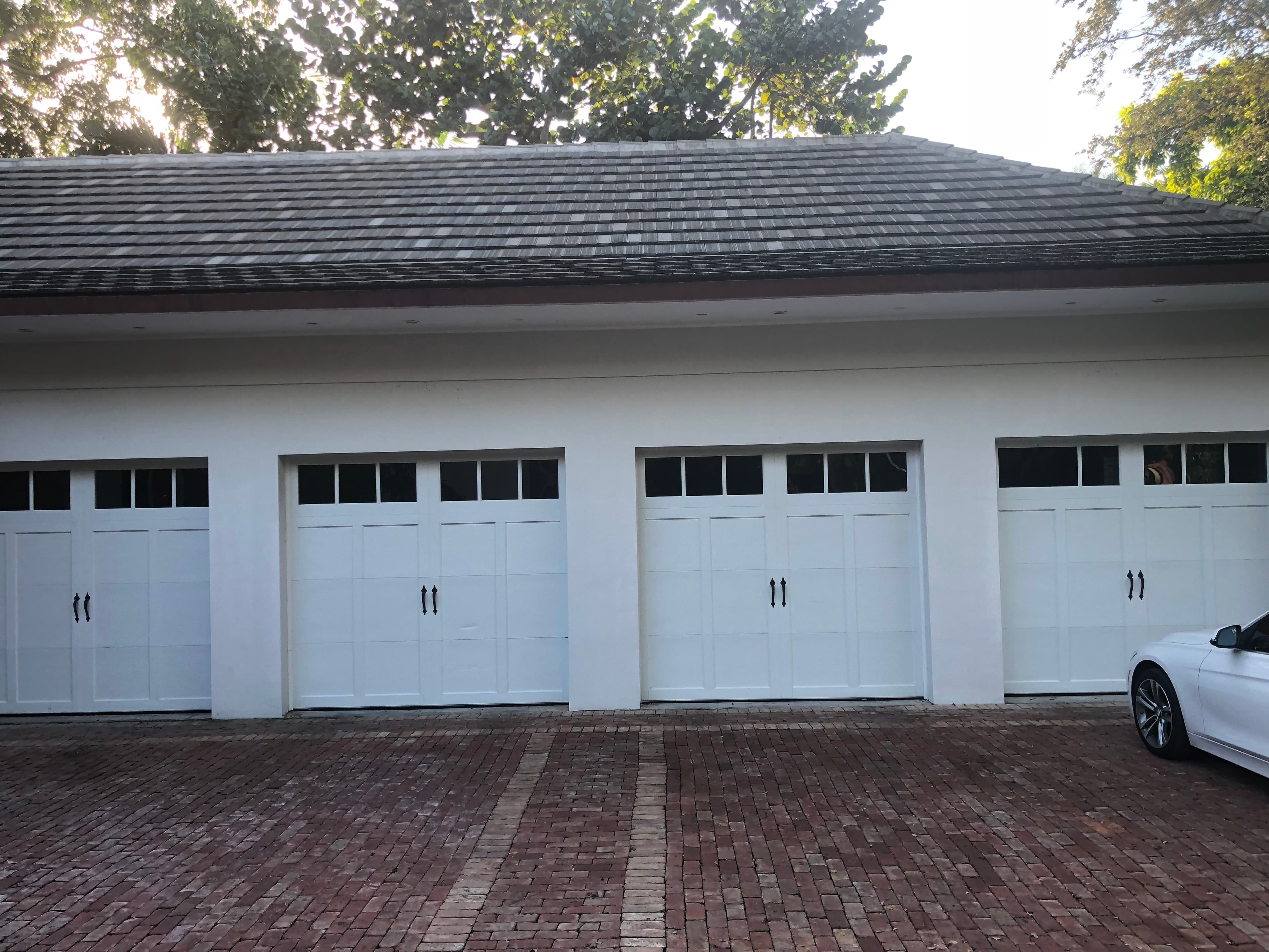 White carriage-style garage doors on a large luxury residential garage building