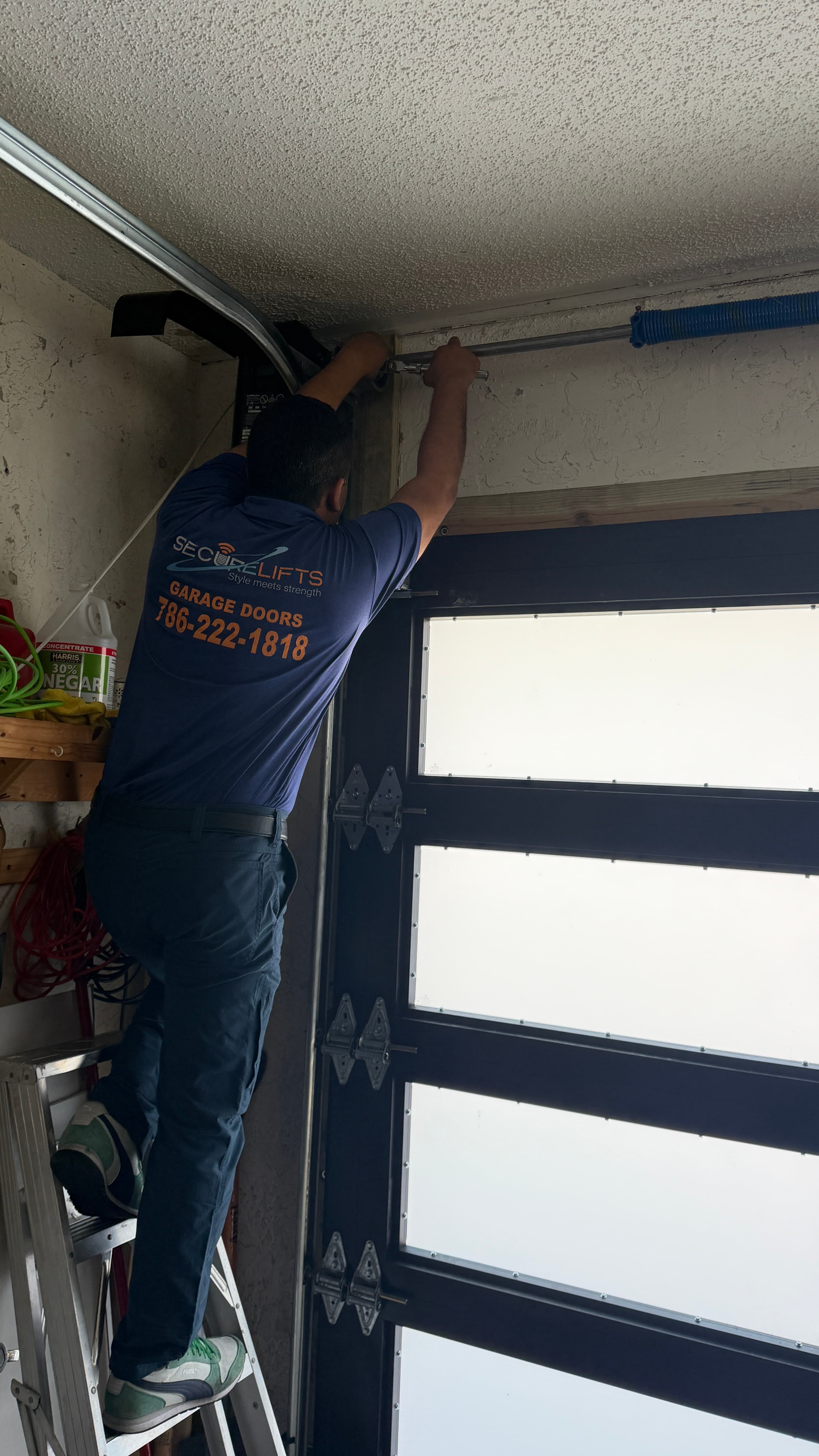 SecureLifts technician installing impact-rated garage door